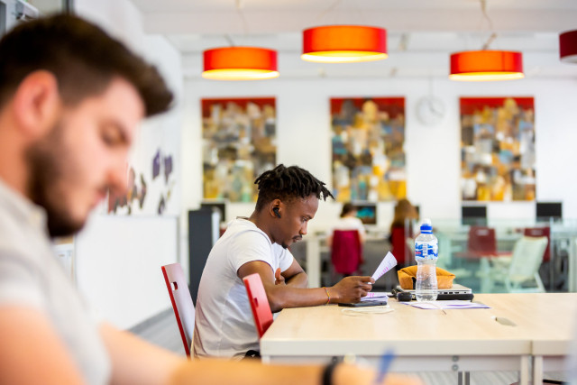 Two students studying at a table in the Central Economics Library.