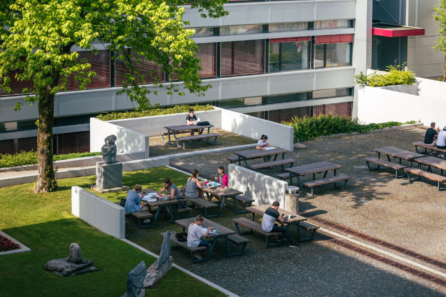 Ptičja perspektiva študentov, ki sedijo za mizami v atriju.