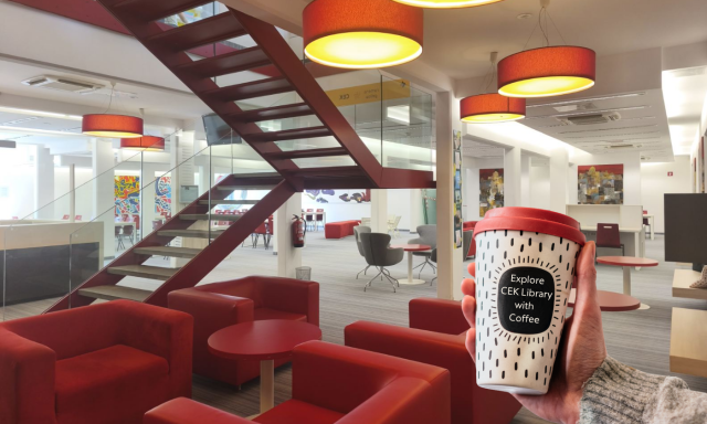 View of Silver*CEK with red armchairs and study spaces in the background. In the foreground, a person is holding a coffee cup with the words »Explore CEK Library with Coffee«. 