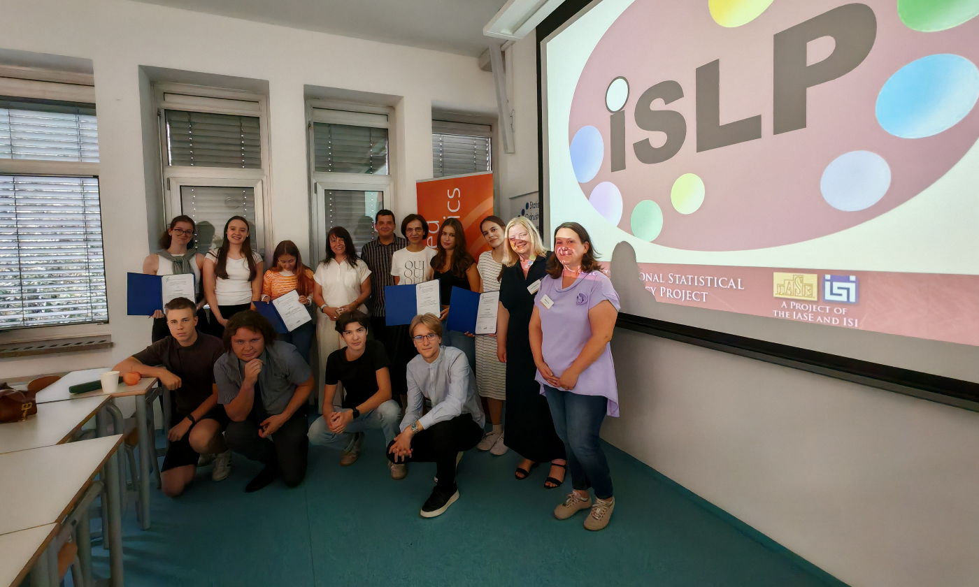 Skupinska fotografija raznolikih ljudi v predavalnici.