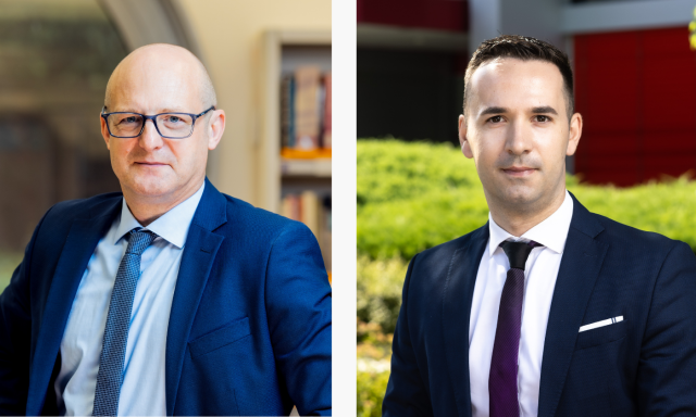 Na sliki sta prikazana dva moška v obleki, ki stojita drug ob drugem. Moški na levi je plešast in nosi očala v zaprtem prostoru, medtem ko moški na desni stoji zunaj, ima kratke lase in resen izraz na obrazu.