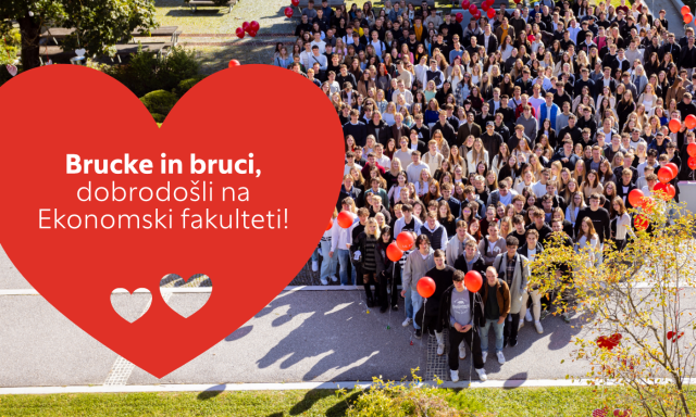 Skupina ljudi stoji pred rdečim srcem z napisom "Brucke in bruci, dobrodošli na Ekonomski fakulteti!"".