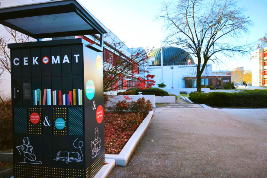 CEKomat in front of the CEK Library, a 24/7 self-service machine for borrowing and returning library materials, located in the outdoor atrium of the School of Economics and Business, University of Ljubljana.
