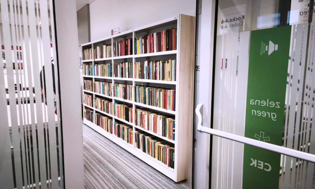 The established shelves of the CEK Bookery (free books library corner), visible from the open doors of Green*CEK.