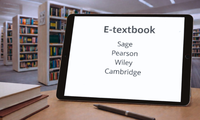 A tablet on a desk in a CEK Library displaying the text ‘E-textbook’ and the publishers Sage, Pearson, Wiley and Cambridge, with bookshelves and books in the background.