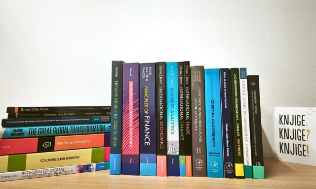 Polica z novimi strokovnimi knjigami s področij ekonomije, financ, managementa in digitalnega marketinga v Knjižnici CEK, med katerimi prevladujejo publikacije založbe Cambridge University Press.