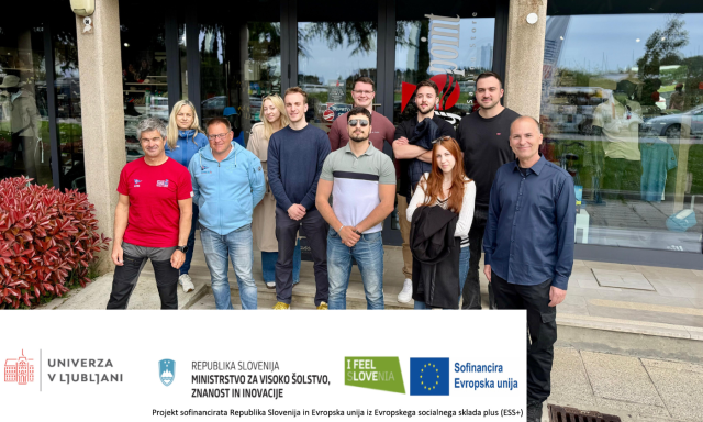 A group of diverse individuals standing together outside a modern building, smiling and engaging with one another.