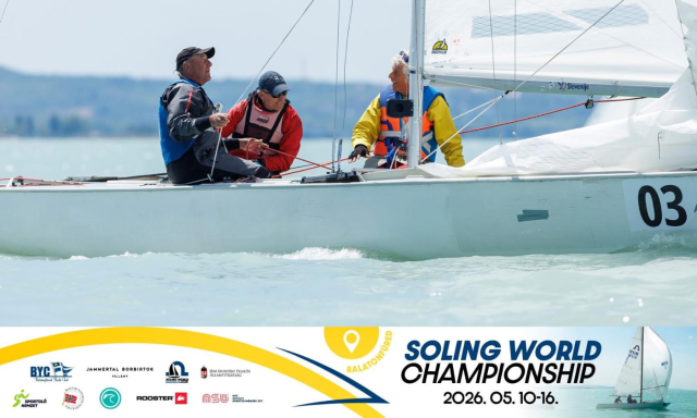 Three sailors on a Soling sailboat race on a calm sea. They look focused and determined, preparing to adjust the sails. Text: "Soling World Championship 2026, 05.10-16."