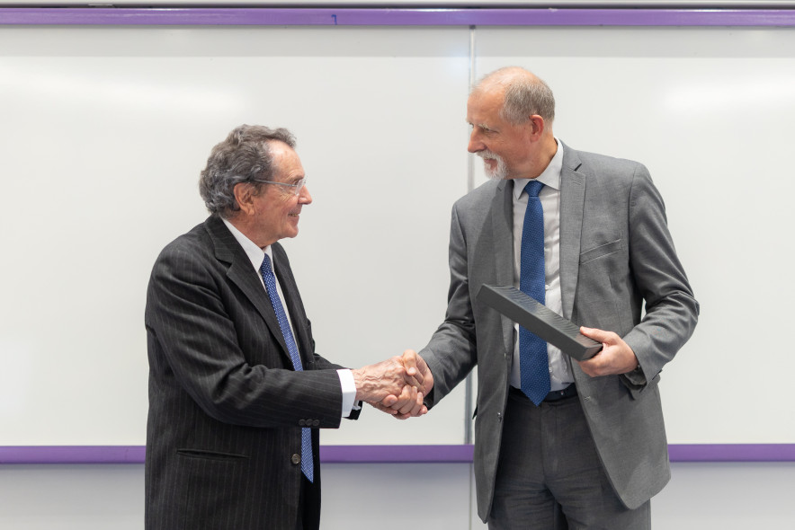  Prof. Gian Maria Gros-Pietro and the Rector of the University of Ljubljana, dressed in business style, shake hands, with a white school board in the background. 