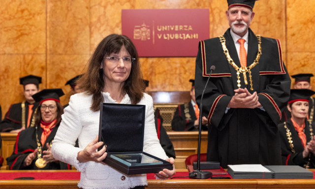 Prof. dr. Andreja Cirman prejema zlato plaketo Univerze v Ljubljani, v ozadju rektor Univerze.  