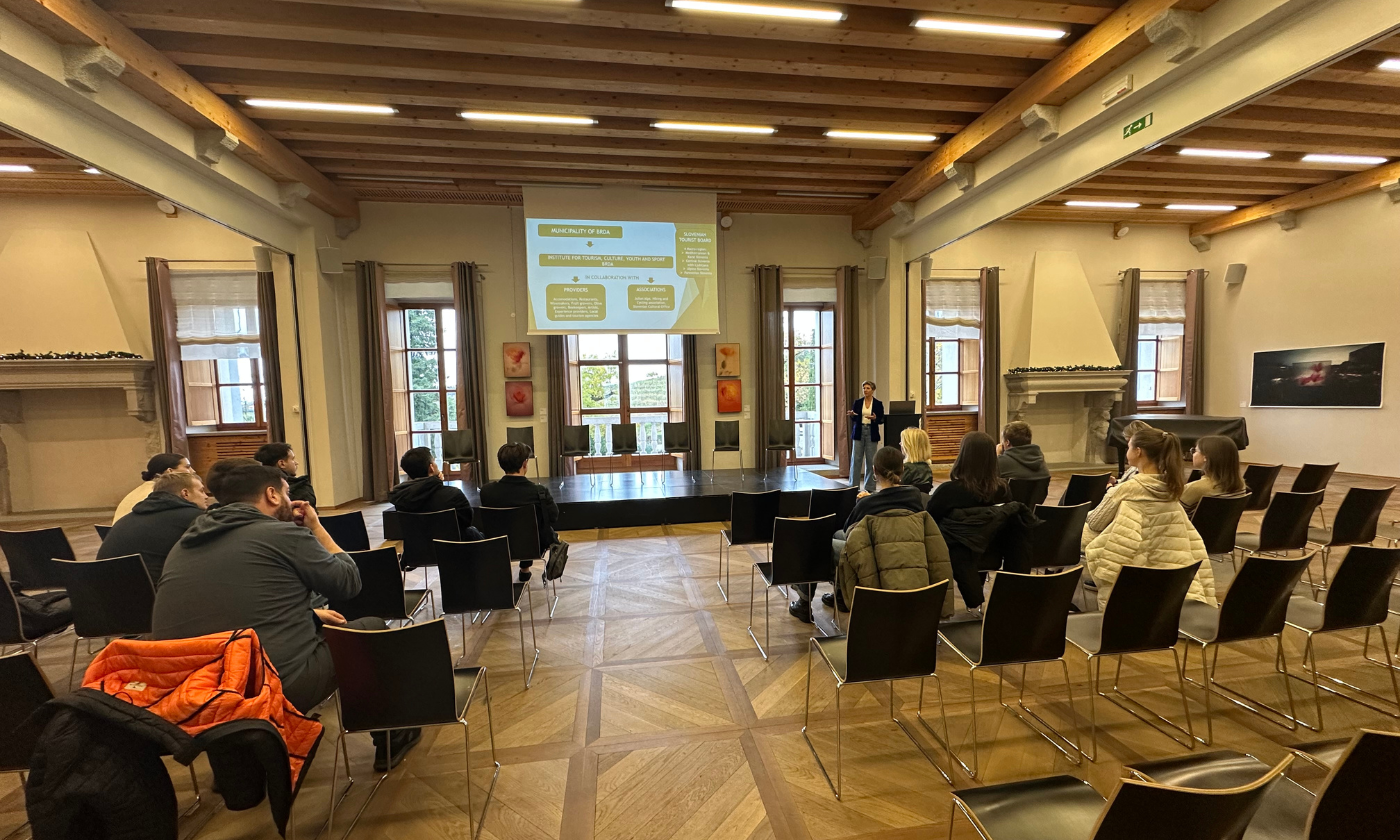 An expansive room where people are seated in chairs, participating in a group discussion.