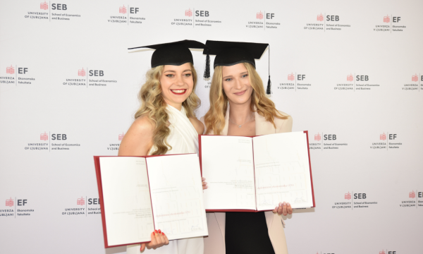 Two students taking a photo after receiving their diploma. 